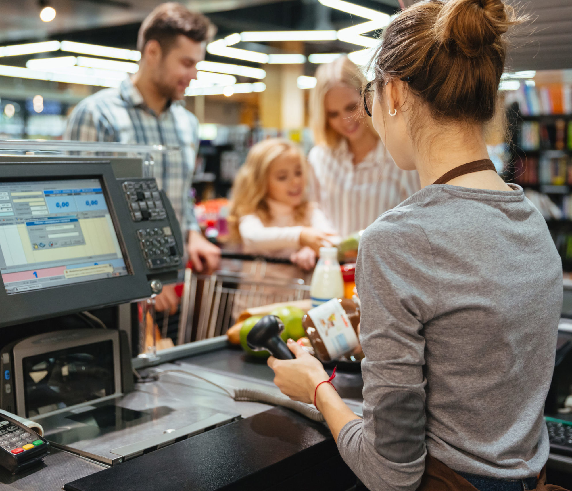 Beautiful family standing at the cash counter